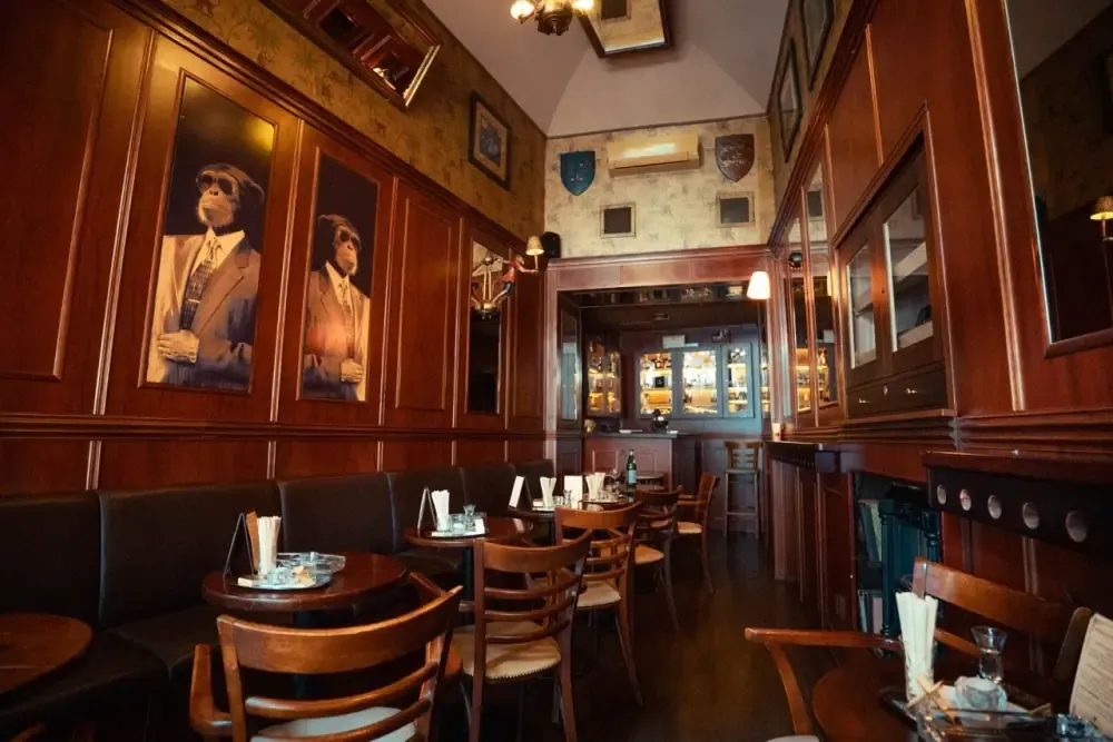 Wood-panelled salon with portraits and leather banquettes